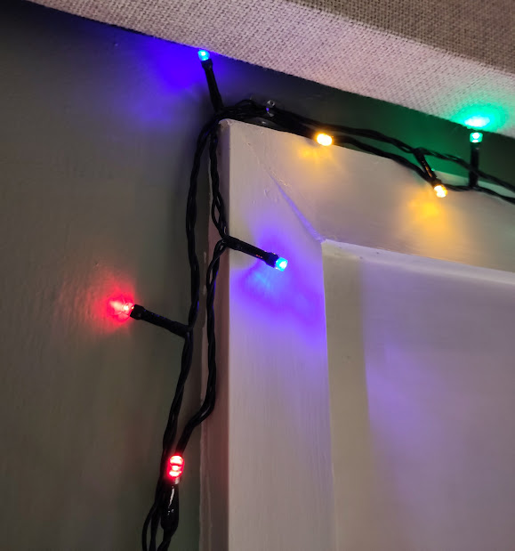 Close up of coloured Christmas lights on a string, indoors